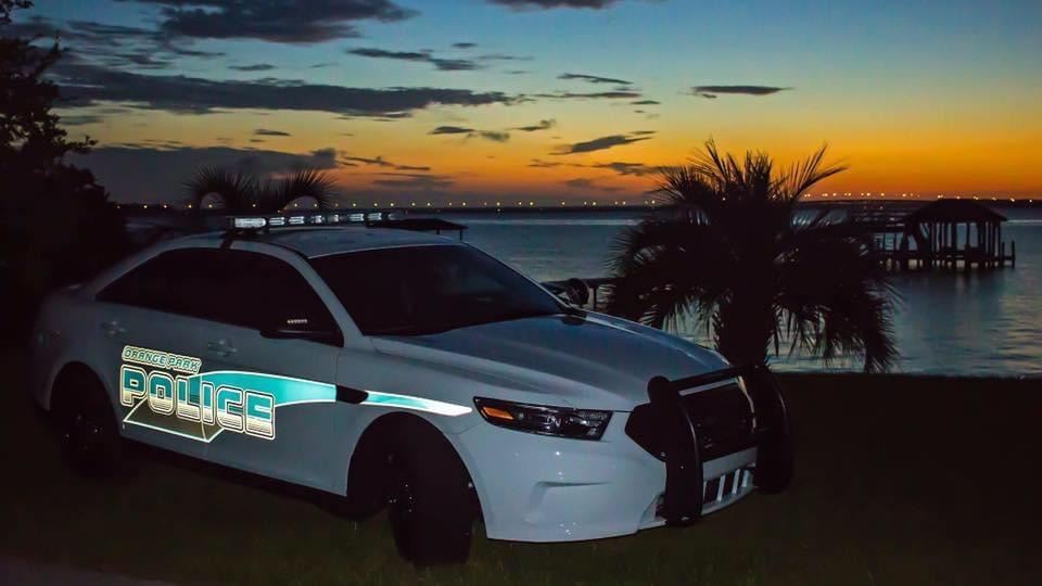 Police sedan by the river with the sun setting