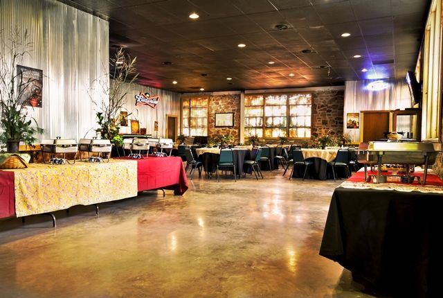 Inside of the Boot Daddy Saloon with a buffet set up and round tables with black linens.