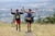 Photograph of two runners at the top of a hill clasping each others  hand overhead in victory