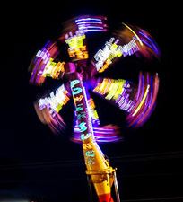 Photo: Night shot of carnival ride spinning high up in the air.
