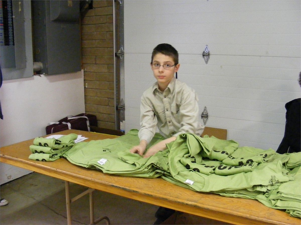 Chance from Campbell Co. Wyoming helping hand out the free T-shirts from Farm Credit Service to all the competing youth