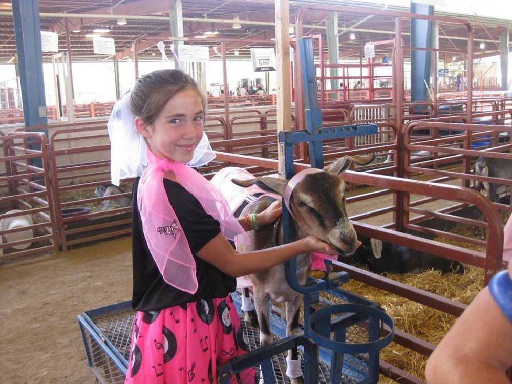 A 4-H youth petting her Goat