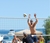 Man volleying a volleyball by the Grand Traverse Bay on the Beach
