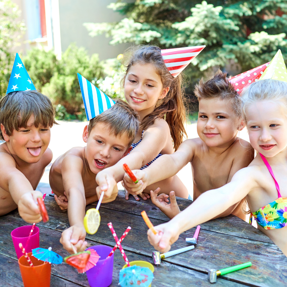 Photo of kids sitting at table playing with party favors