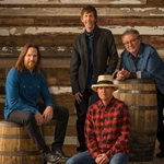 the members of the band Sawyer Brown sitting on barrels