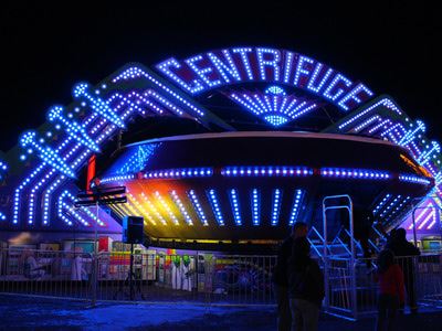 Centrifuge ride at night with several blue lights
