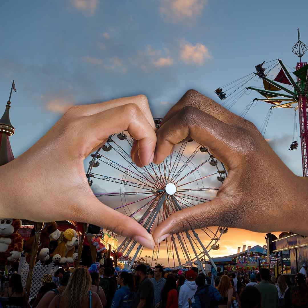 Children's hands shaped like a heart with Ferris wheel in background