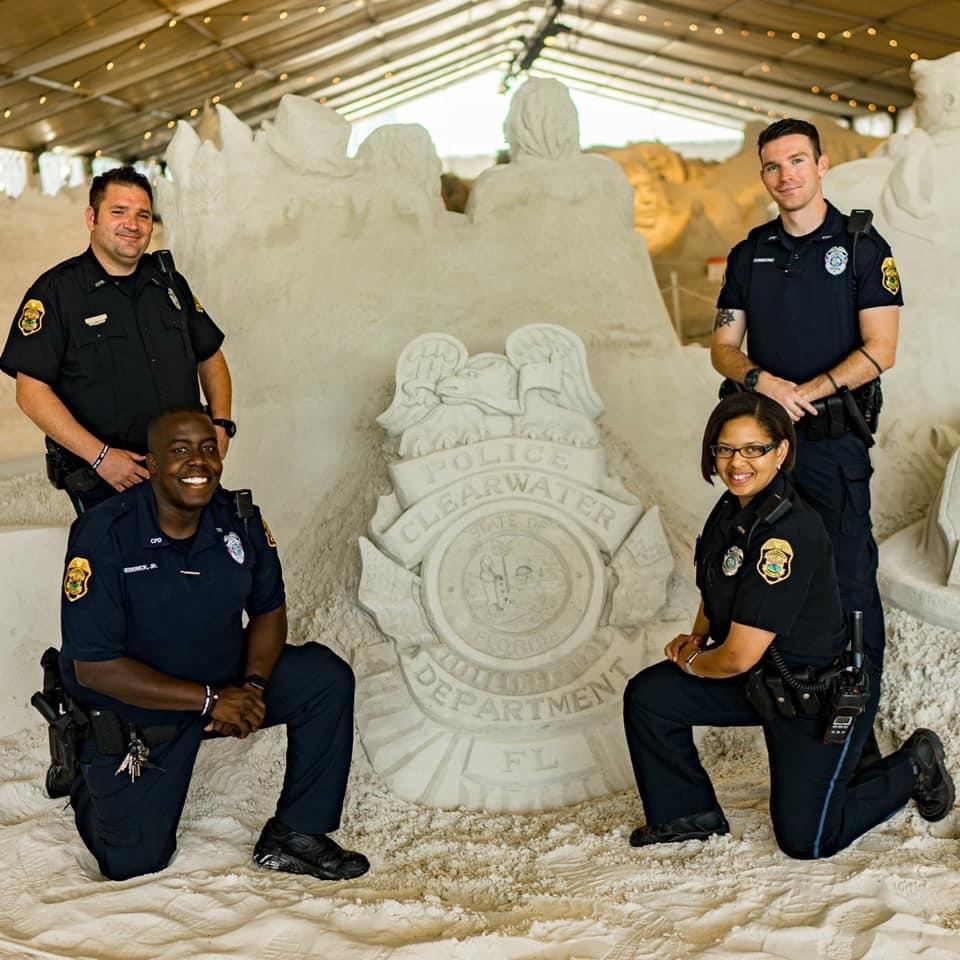 Firefighters in front of a sand sculpture