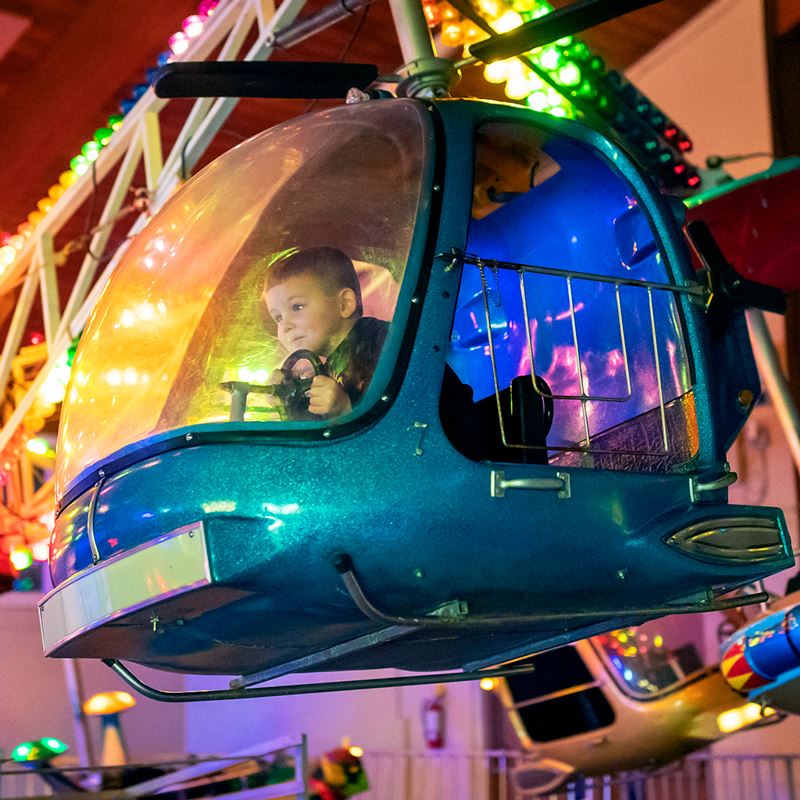 Little boy riding inside a helicopter ride