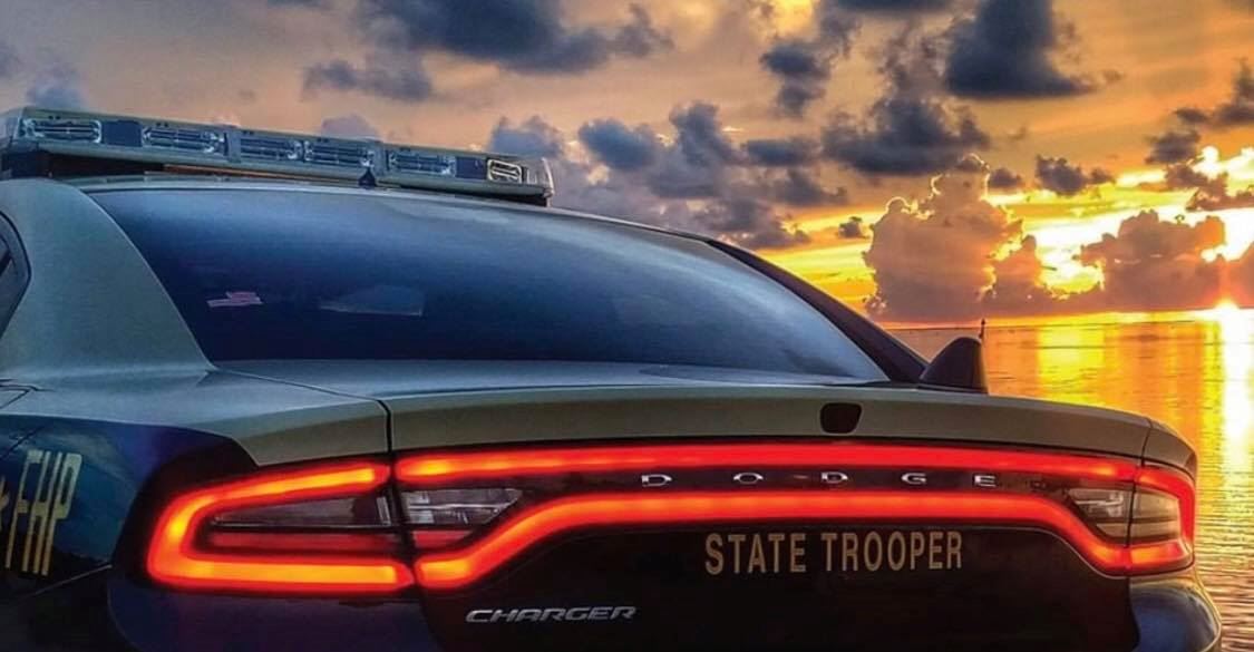 Rear of state trooper sedan with the sunset in the background.
