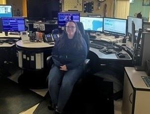 Photo of police dispatch center with operator sitting in a chair.