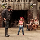 Little Girl in pink with Sheriff and bandits tied up at Knott's Berry farm in Buena Park, CA
