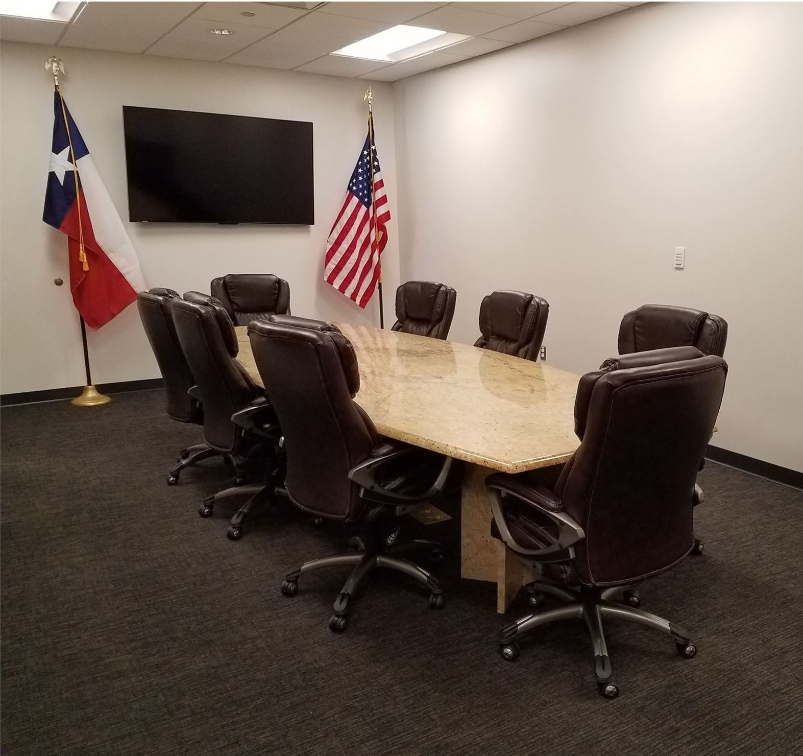 Empty Confrence room with large table and eight office chairs around the table